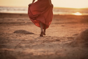 Eine Frau geht alleine am Strand