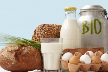 Bio Lebensmittel wie Milch, Eier und Brot stehen nebeneinander