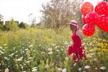 Eine Frau trägt rote Ballons