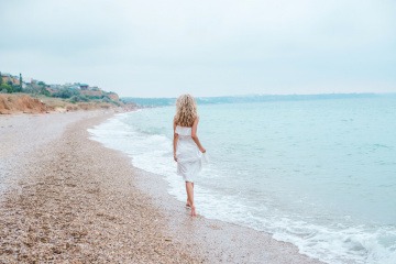 Eine Frau geht am Strand spazieren