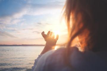 Eine Frau steht vor einer Sonne